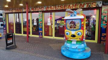 An arcade entrance with a large, colorful game machine in front.