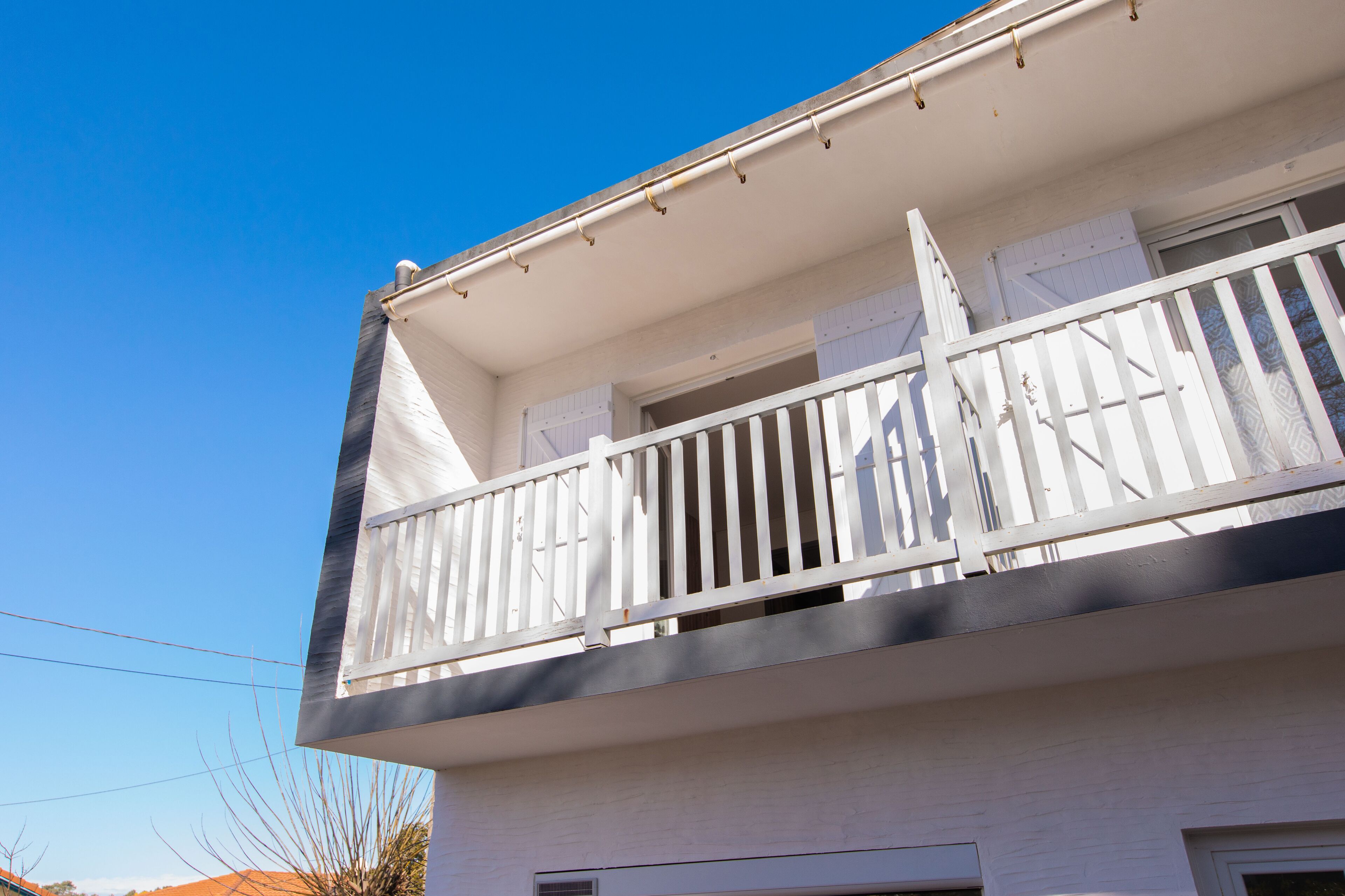 Un bâtiment blanc doté d’un balcon.