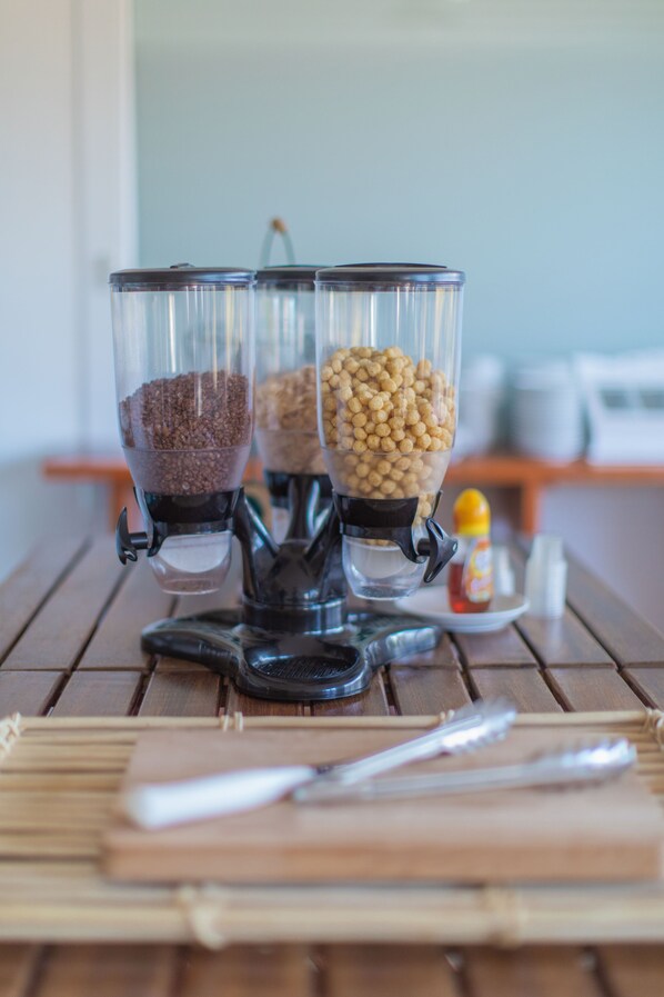 A coffee grinder with three containers of coffee beans on a wooden table. - Land'Azur (Mimizan)