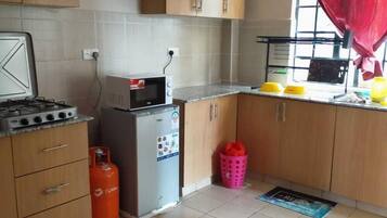 Comfort Apartment | Private kitchen | Fridge, microwave, cookware/dishes/utensils, dining tables
