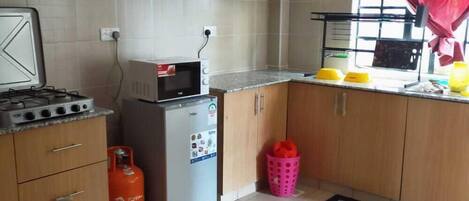 Comfort Apartment | Private kitchen | Fridge, microwave, cookware/dishes/utensils, dining tables