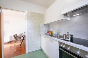 A kitchen with white cabinets, a stove, and a sink. - Lido Apartment Locarno With Balcony and Parking (Locarno)