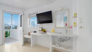 A modern bathroom with a white vanity, a mounted television, and a large mirror. - Bella View Mykonos Town Suites (Mykonos)