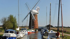 A windmill with boats docked nearby.