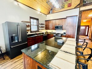 A kitchen with a refrigerator, microwave, stove, and granite countertop. - Trestle Ridge Cabin - Teen, Kid, Parent, Grandparent-Friendly + free train and rafting tix (Bryson City)