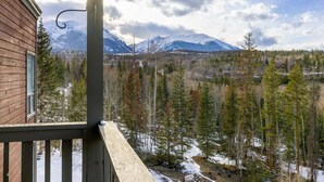 A wooden cabin with a balcony overlooking a snowy mountain landscape and a forest. - Cozy Top Floor Condo w/ Incredible Mountain Views from Private Balcony! (Silverthorne)
