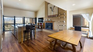 A spacious kitchen with a large island, wooden flooring, and a dining area with a table. - Cozy Top Floor Condo w/ Incredible Mountain Views from Private Balcony! (Silverthorne)