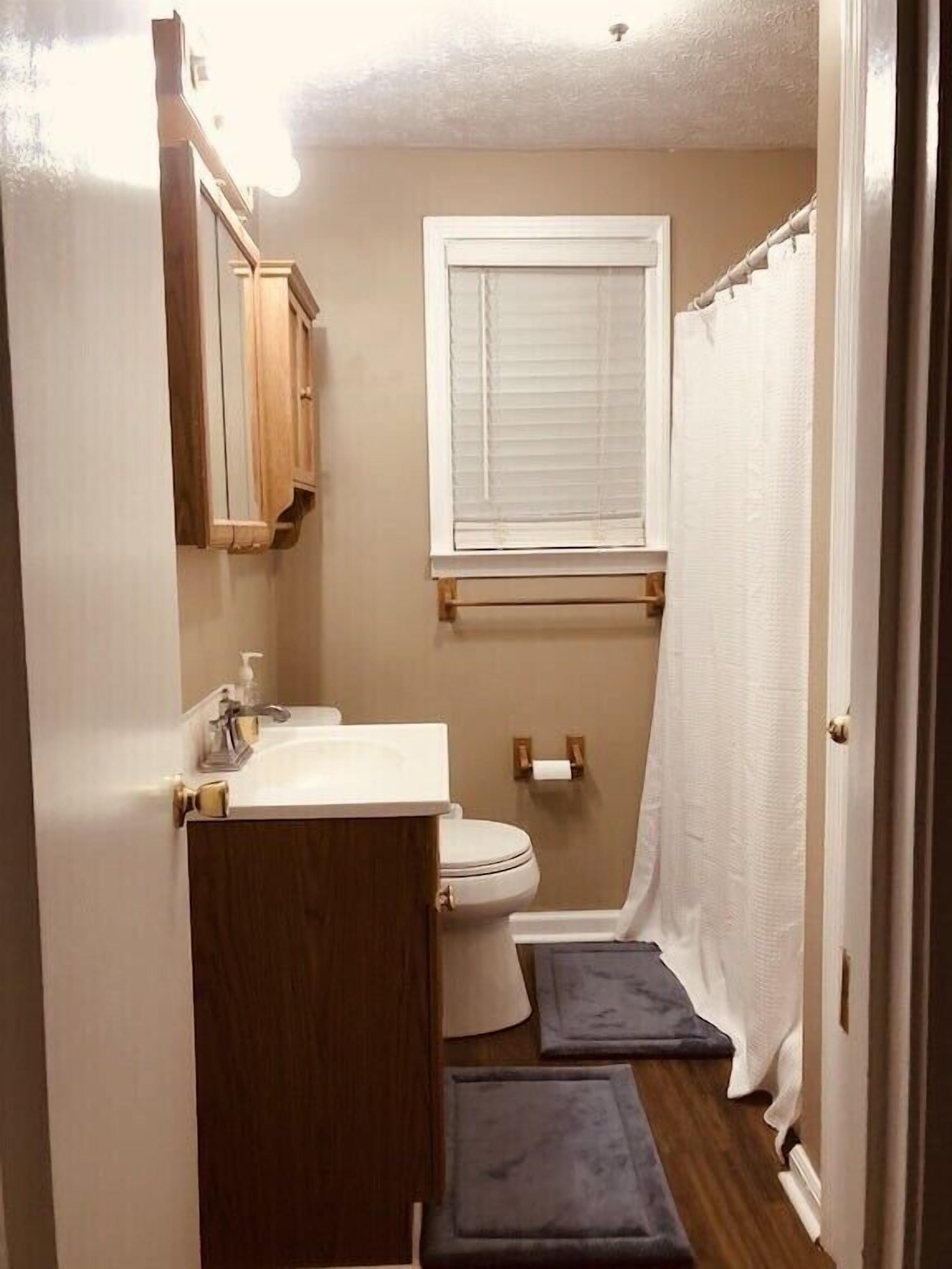 Un baño pequeño con inodoro, lavabo y ventana.