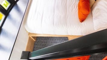 Una cama con ropa blanca, una almohada y una señal encima.