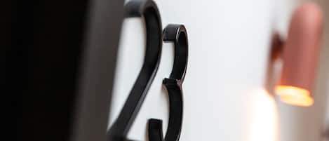 A close-up of a black, curved metal sign with the number "23" on a white background.