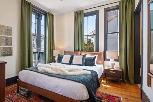 Restful retreat with a large bed, wooden headboard, and a nightstand with a lamp.