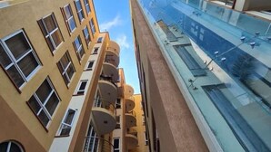 A high-rise building with multiple balconies and a glass facade. - Stay.Plus APA Apartments Nyali (Mombasa)