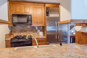 Enjoy cooking and meal prep in this well-equipped kitchen with a sink, coffee maker, and modern appliances.