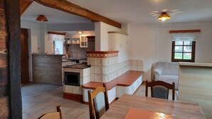 Un'ampia cucina con isola centrale, travi in legno e luci a sospensione.