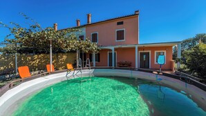 A house with a swimming pool, orange chairs, and a clear blue sky. - Ines in Barban  - Haus für 4-5 Personen (Barban)
