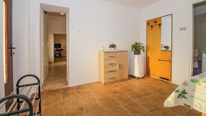 A room with a wooden cabinet, a mirror, a small table with a plant, and a chair. - Ines in Barban  - Haus für 4-5 Personen (Barban)