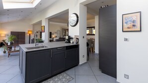 A modern kitchen with dark cabinets, a large island, and a skylight. - Spacious villa on Lake Soustons (Soustons)
