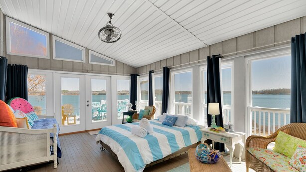 Ein geräumiges Zimmer mit einem großen Bett, einem Schreibtisch und Blick auf das Wasser.