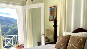 A bedroom with a large bed, a view of the outdoors, and a painting on the wall. - Starlight Chalet (Silver Hill Gap)