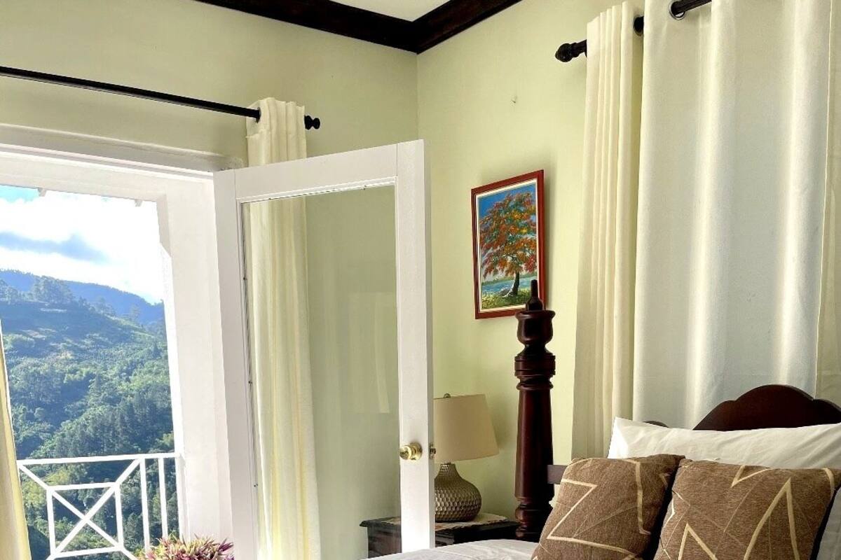 Un dormitorio con una cama grande, vistas al exterior y un cuadro en la pared.