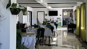 A restaurant with tables and chairs, a ceiling light, and a tiled floor. - Starlight Chalet (Silver Hill Gap)