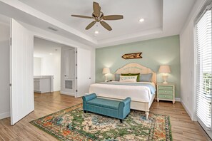 A bedroom with a bed, bedside tables, a ceiling fan, and a view of the outside through a window. - Last Minute Disney Getaway! Villa with Private Pool & Hot Tub. Book Now! #39456 (Kissimmee)