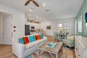 A modern living room with a sofa, coffee table, and dining area. - Last Minute Disney Getaway! Villa with Private Pool & Hot Tub. Book Now! #39456 (Kissimmee)