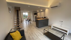 A modern living room with a sofa, a coffee table, and a staircase. - Cosy ALL NEW cottage with swimming pool- (Tanneron)
