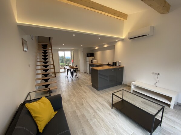 A modern living room with a sofa, a coffee table, and a staircase. - Cozy, brand-new cottage with a swimming pool (Tanneron)