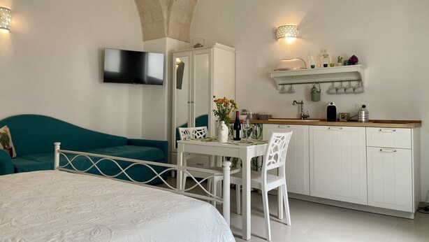 A compact bedroom with a bed, a desk, and a kitchenette. - Apartment at 500 meters from the sea (Monopoli)