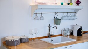 A kitchen with a wooden countertop, a white sink, and a hanging pot rack. - Apartment at 500 meters from the sea (Monopoli)