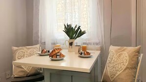 A dining area with a table set for breakfast, including croissants, a coffee pot, and a plant. - Central cosy home 5 minutes walk from Shrewsbury - Pass the Keys (Shrewsbury)