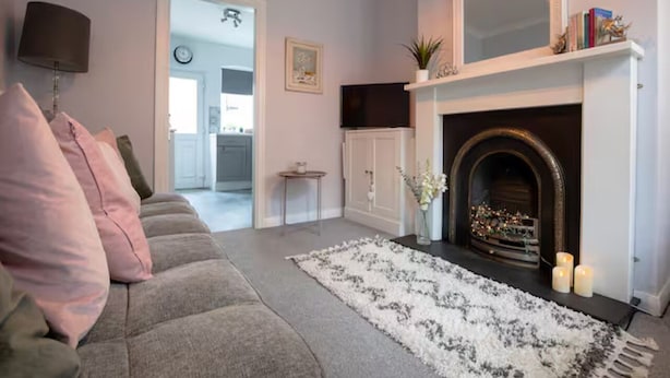 A living room with a fireplace, a sofa, a rug, and a television. - Central cosy home 5 minutes walk from Shrewsbury - Pass the Keys (Shrewsbury)