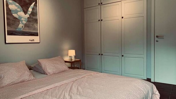 A bedroom with a bed, a nightstand, a wall-mounted painting, and a wardrobe. - Résidence vallée de la Meuse 2 - Blaimont (Blaimont)