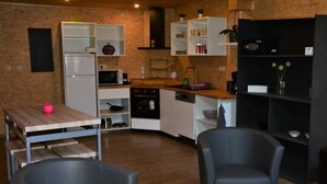 Une cuisine moderne avec des armoires blanches, un plan de travail en bois et une bibliothèque noire.