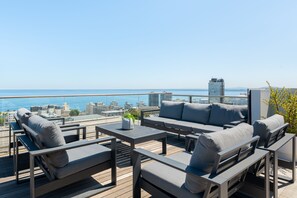 A rooftop terrace with outdoor furniture, a view of the city, and a clear sky. - One Calais | Cozy Studio | Wifi + Netflix (Cape Town)