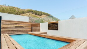 Ein Schwimmbecken mit Holzdeckung und weißen Wänden, sowie ein Schild mit einem Hinweis zum Schwimmbadbetrieb.