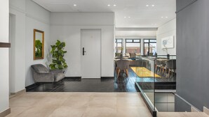Ein modernes Interieur mit Wohnbereich, Essbereich und einer Treppe zu einer oberen Etage.