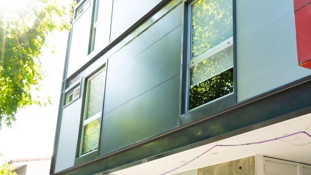 En moderne bygning med store vinduer og en glasindgang, med skiltet "Cinco Soles Hotel".