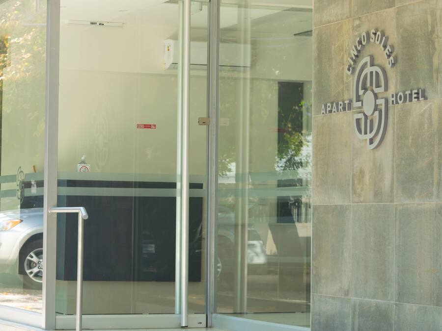 Ingresso con porta in vetro a un hotel, con un cartello che riporta la scritta