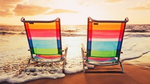 Two beach chairs facing the ocean with a sunset in the background. - Sandy Bits Oceanfront Premium Condo with Pool (North Myrtle Beach)