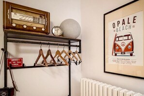 Eine Wand mit einem alten Radio, einer Uhr, einem kugelförmigen Objekt und einem gerahmten Poster eines Lieferwagens.