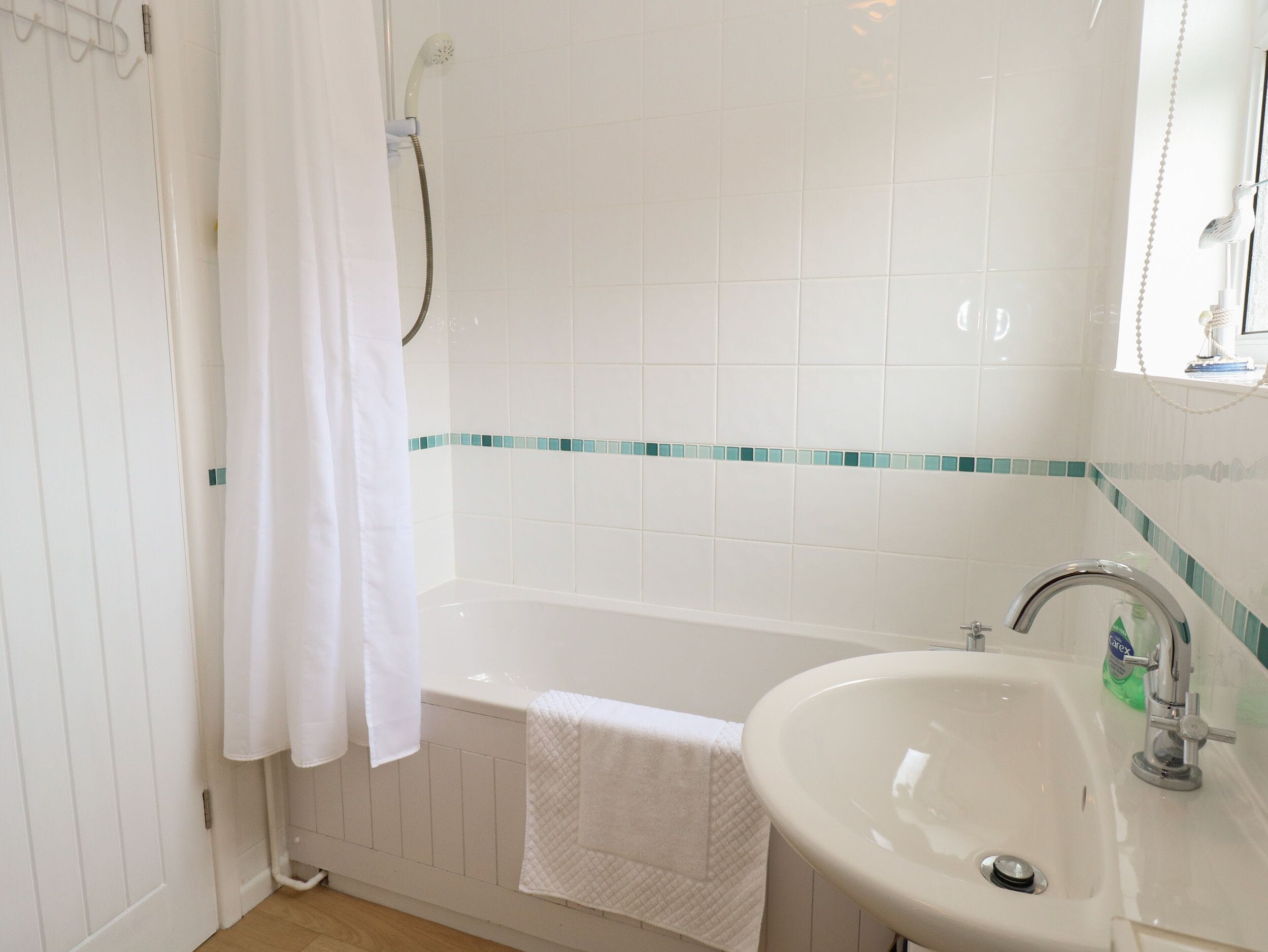 A bathroom with a bathtub, a sink, and a shower.