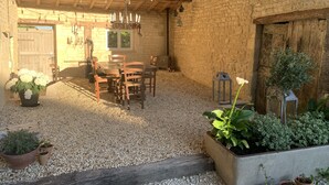 A rustic interior with a wooden table and chairs, a chandelier, and potted plants. - Gîte des Ruches, Peaceful & Homely 1 bedroom Gîte with pool (Chives)