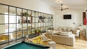 A modern living room with a pool table, comfortable seating, and a large mirror reflecting the space. - The Boc Hostels Palma - Youth Hostel (Palma de Mallorca)