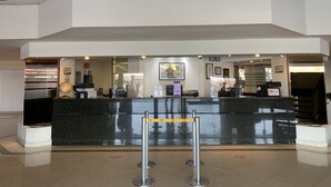 A hotel reception area with a modern design, featuring a reception desk, a globe, and a chandelier. - Hotel Fastos (Monterrey)