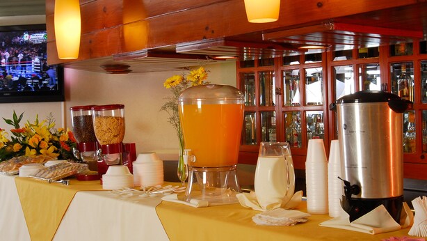 A buffet table with food, drinks, and a coffee maker. - Hotel Fastos (Monterrey)
