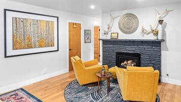 A living room with a fireplace, a framed painting, and antler decorations.