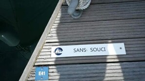 Una terraza de madera con un letrero que dice "SANS SOUCI" y un letrero azul con "E41".