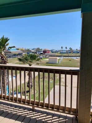 Un balcón con vista a un puerto deportivo, con barcos y edificios.